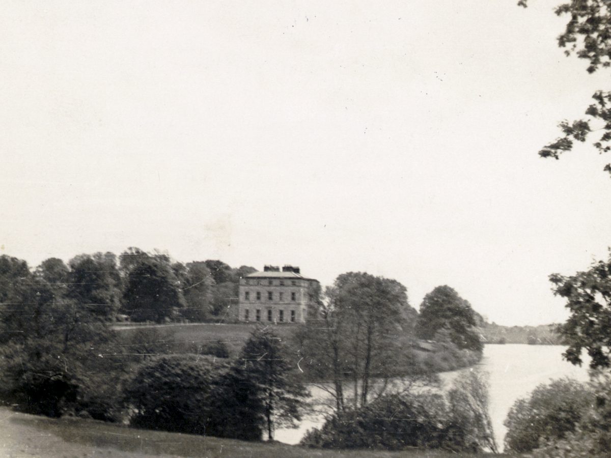A vintage photograph of Seaforde House seen across the lake.