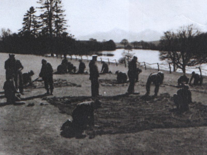 Troops preparing to install the Quonset huts on the lawn above the lake, 1942.