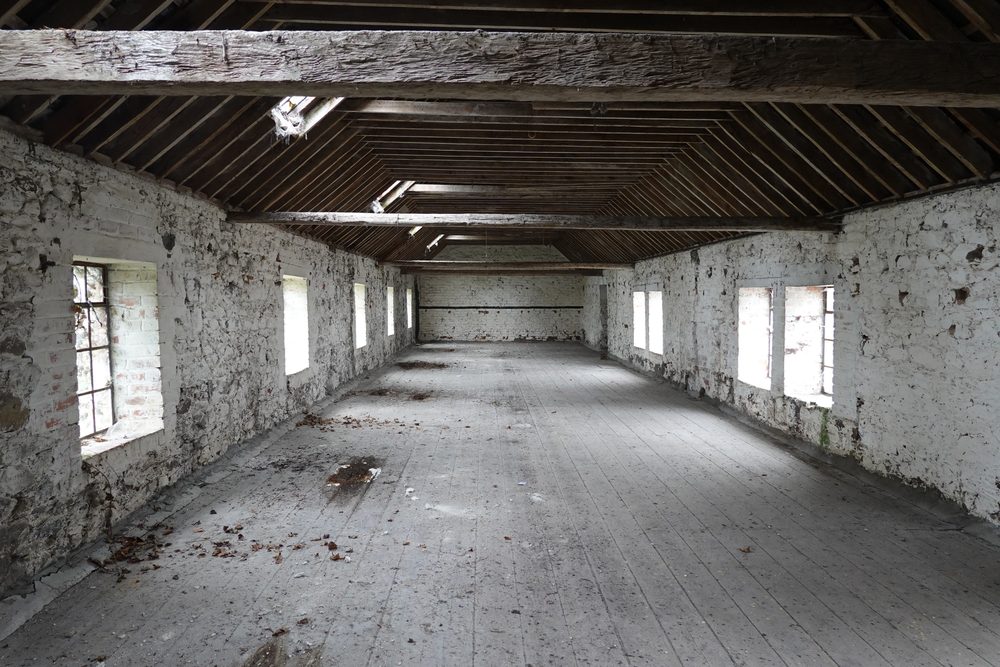 Inside a long loft, whitewashed brick walls and an open timber roof.