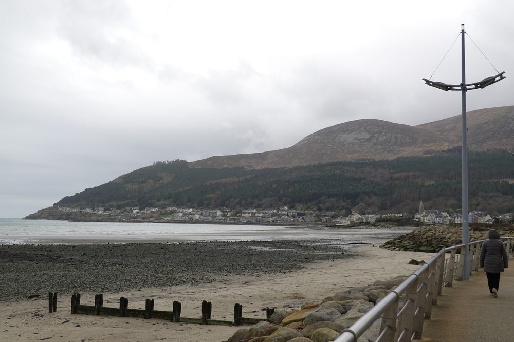 The Mournes today, rising behind the Newcastle seafront and sweeping down to the sea.