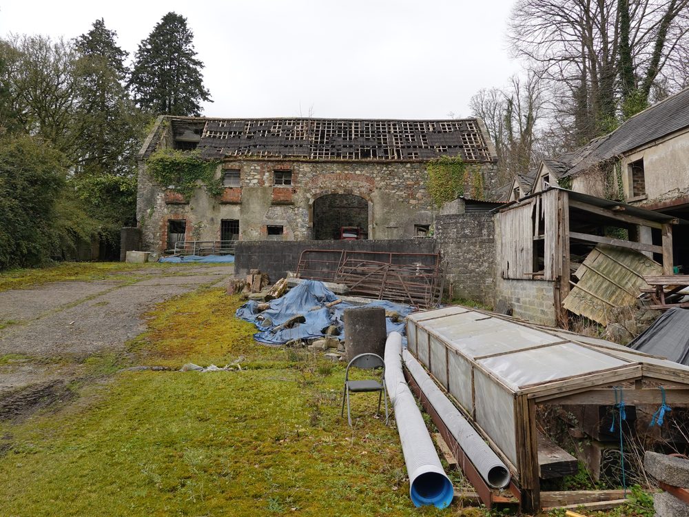 The same outbuildings today, roof caved in, ivy overtaking the stone.