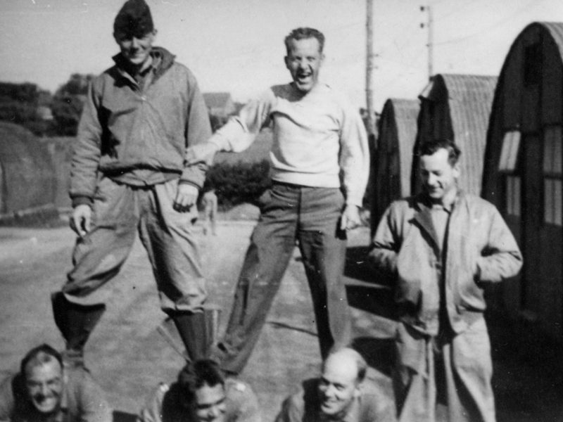Papa, at the top left, standing with other GIs in a row of the Quonset huts, 1942.