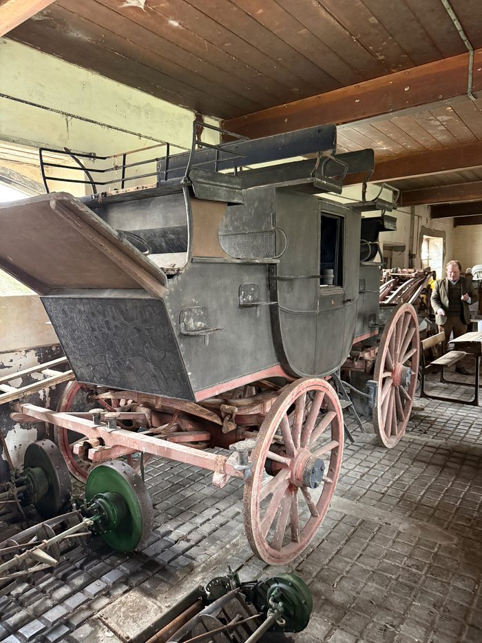 An old horse-drawn carriage stored inside one of the stable buildings.