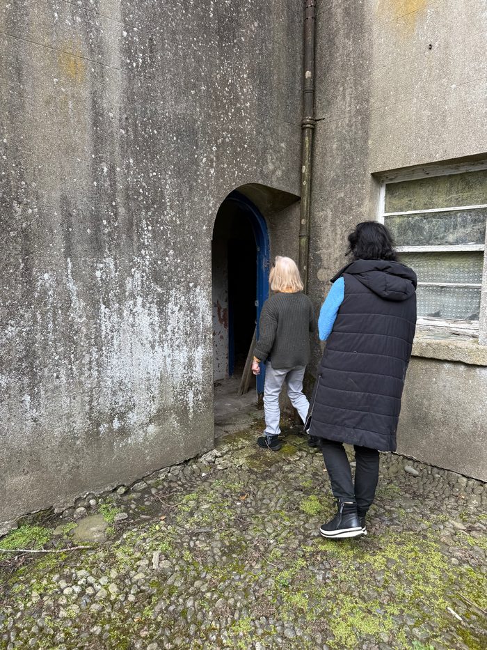 Walking toward a small arched doorway with a blue door, heading into one of the buildings.